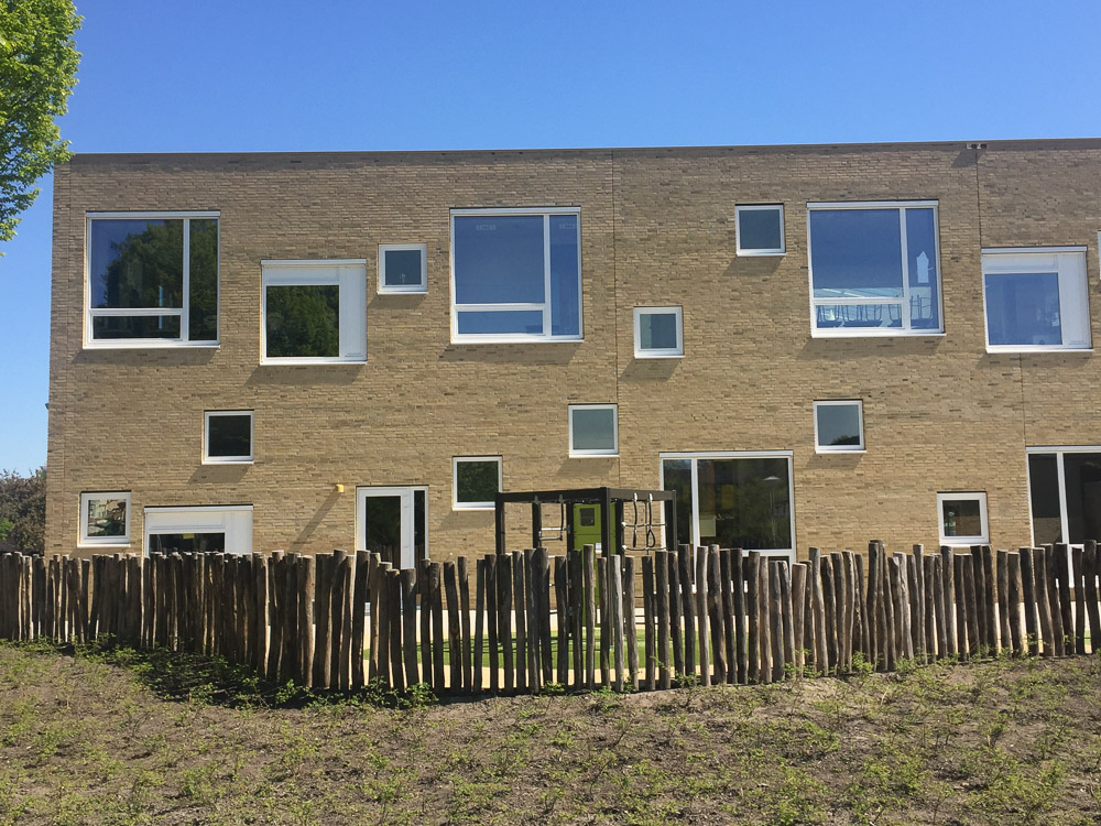 Gevel aan het groene schoolplein van de Toverberg